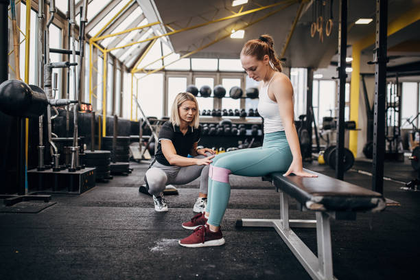 istock Female personal trainer assisting a woman in training 1287491631