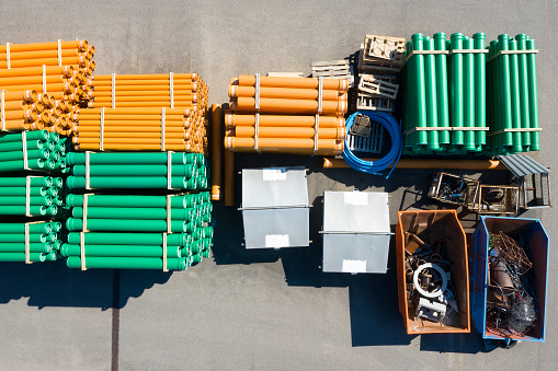 PVC plastic pipes for underground water supply and water meter covers viewed from above at a depot.