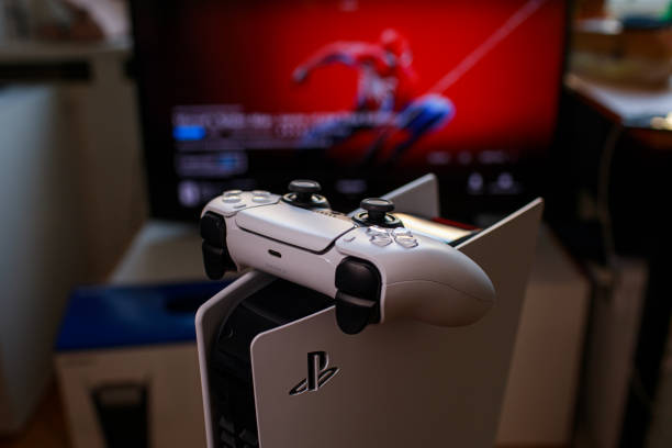 Sony PlayStation 5 console and games Riga, Latvia - November 23 2020: Sony PlayStation 5 game console on black background.  Spider-Man: Miles Morales is PS5's biggest launch game. Man holding joystick gamepad photos stock pictures, royalty-free photos & images