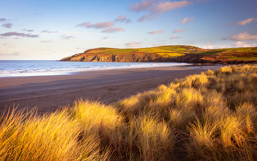Sand dunes, beach and headland at sunrise in Pembrokeshire, Wales