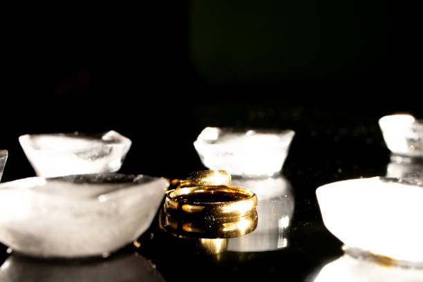 istock Two golden wedding rings on black background. 1287494888