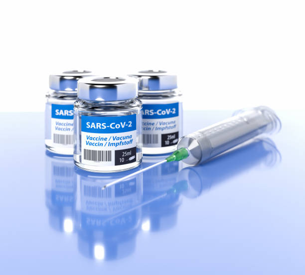 istock Vaccination against Corona Virus SARS-CoV-2 / Covid-19: Three bottles with 10 doses each and a syringe. The word vaccination in English, Spanish, French and German on the label. Selective focus 1287496409