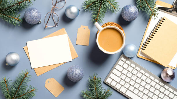 istock Flat lay Christmas home office desk with pine branches, keyboard, coffee cup, balls, Christmas decorations on pastel blue background. Cozy, hygge, nordic style. 1287496509