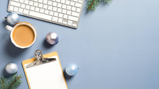 istock Flat lay Christmas home office desk with pine branches, keyboard, coffee cup, Xmas decorations on pastel blue background. Cozy, hygge, nordic style. 1287496514