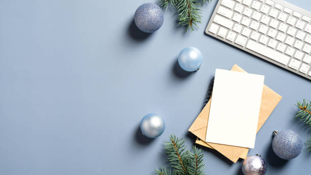 istock Modern home office desk with keyboard, pine branches, balls on pastel blue background. Elegant Christmas workspace. Flat lay, top view. Cozy, minimal, nordic style. 1287496515