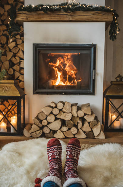 Winter day by fireplace Lazy winter day in front of fire in fireplace. Human legs in socks in front of fireplace. heat home interior comfortable human foot stock pictures, royalty-free photos & images