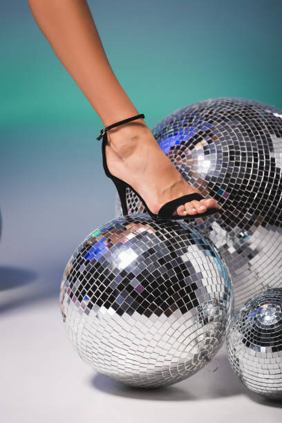 istock female leg in black shoe on disco ball 1287504282