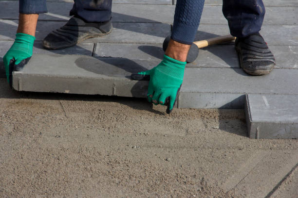 istock Brick Paver Working. Worker lay paving tiles, construction of brick pavement. Architecture background 1287510284