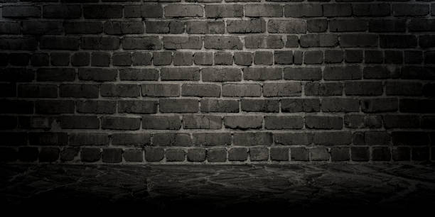 istock Empty dark brick wall, studio room, for displaying your products. Texture of marble floor and brick wall. 1287510501