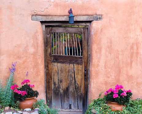 Santa Fe Style: Rustic Wood Door in Adobe Wall, Geraniums