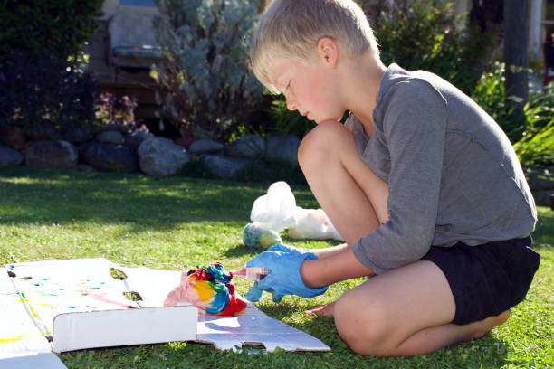 istock Child Making Tie Dye T-Shirt 1287514168