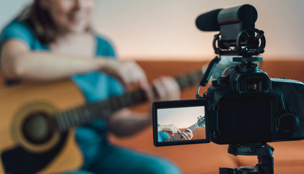 istock Happy woman teaching guitar lesson on internet with video tutorial - Social distance music concept - Focus on camera 1287518440