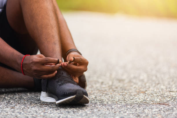 istock runner black man sitting shoelace trying running shoes 1287521139