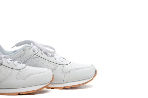 istock Toes of New White Modern Trainers Placed over Over White Background.Horizontal image 1287521320
