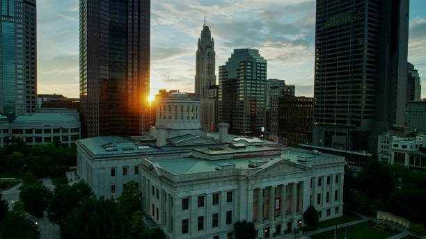 Sun Disappearing Behind Ohio Statehouse - Aerial Aerial establishing shot of the Ohio Statehouse in Columbus at sunset. ohio ohio statehouse columbus state capitol building stock pictures, royalty-free photos & images