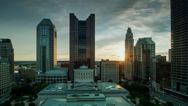 Sun Disappearing Behind Columbus Skyline Aerial establishing shot of the Ohio Statehouse in Columbus at sunset. ohio ohio statehouse columbus state capitol building stock pictures, royalty-free photos & images