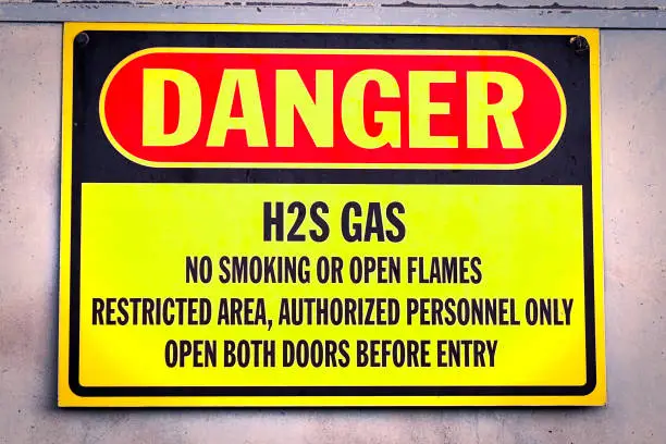 Closeup of a yellow Danger H2S Gas sign.