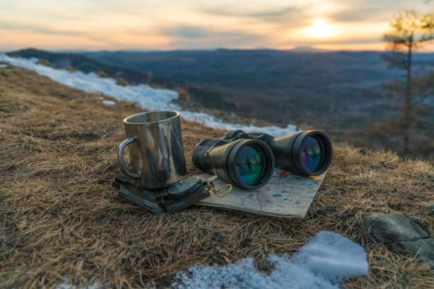 istock Area map compass binoculars and a mug on a mountain top with sunset. Travel trip tourism concept. 1287532549