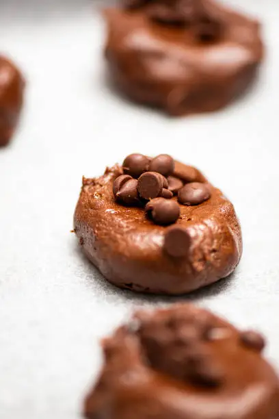 Classic chocolate chip cookies being prepared before baking, food background.