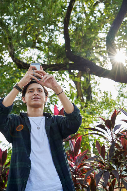 istock young man takes photos with his smart phone camera outside 1287538653