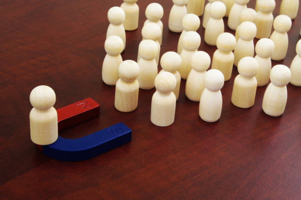 istock Leader with magnet attracting people. 1287544022