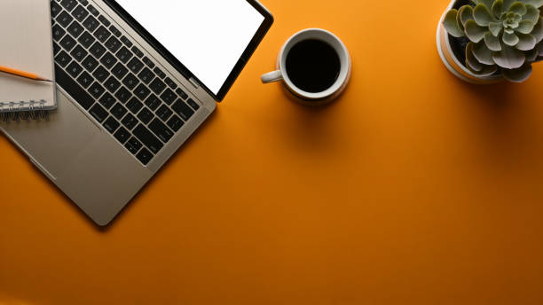 istock Workspace with laptop, coffee cup, plant pot and copy space in home office 1287547533