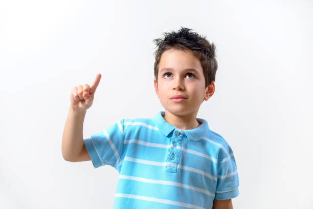 istock A boy in a blue T-shirt with a brooding face raised his finger up. 1287547817