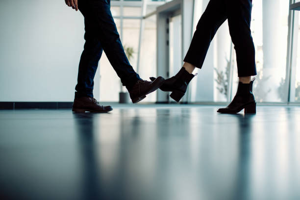 istock Unrecognizable business people foot bumping in a hallway. 1287548500