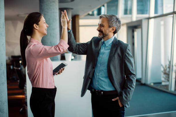 istock Two happy entrepreneurs giving high-five while standing in a hallway. 1287548781
