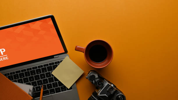 istock Worktable with laptop, camera, stationery and copy space on the table 1287549602