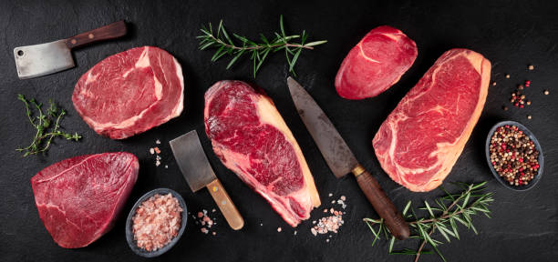istock Meat panorama. Various beef steaks, a flat lay top shot on a black background 1287551826