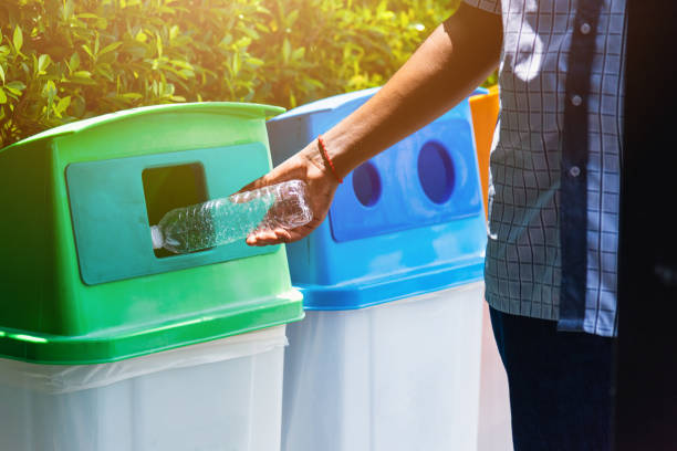 istock black hand throwing an empty plastic water bottle in the recycling garbage trash 1287553925
