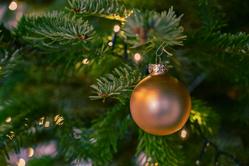 Christmas Fir Tree decorated with christmas balls and defocused lights on the backgorund. Copy space for use as background image.