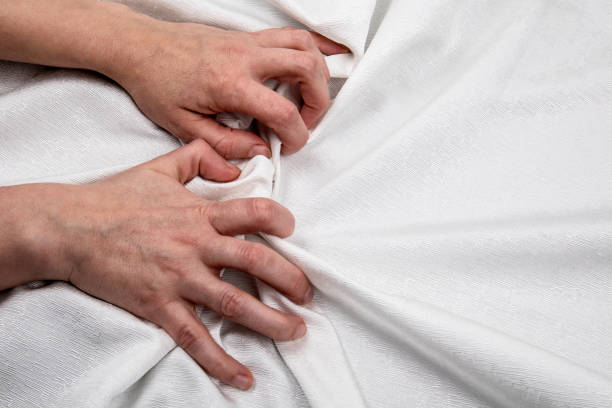 istock Two hands on a white cloth. Symbolizes stress, passion, love and sexual relationships 1287554156
