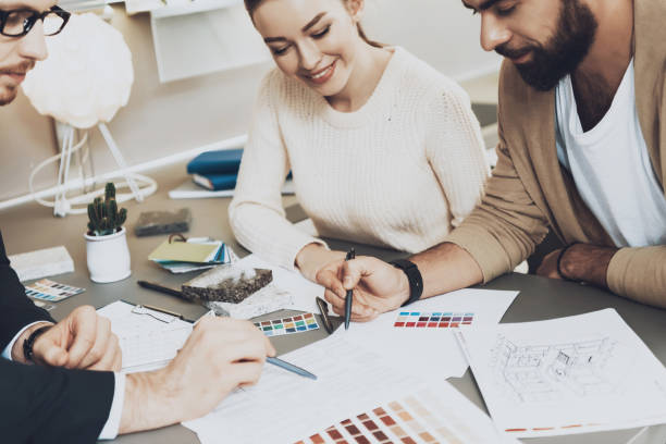 istock Manager is showing documents to couple clients in kitchen store. 1287555644