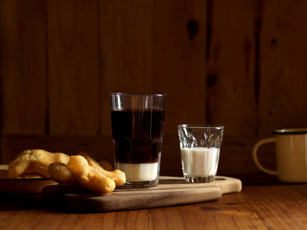 istock Thai style breakfast with coffee and deep fried dough sticks on wooden table 1287555755