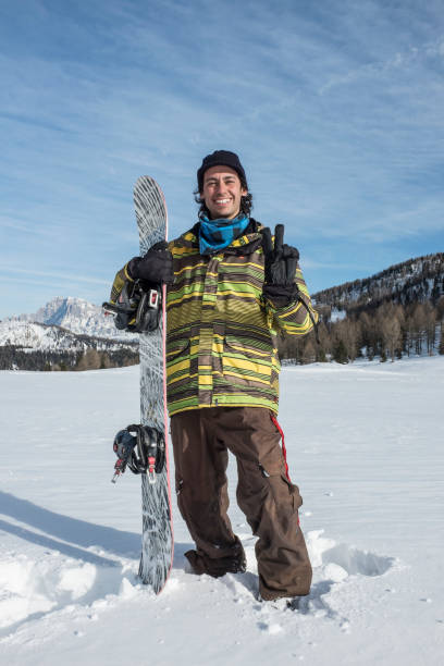 istock young man with snowboard in the mountains 1287556639