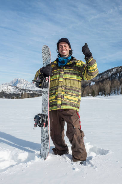 istock young man with snowboard in the mountains 1287556648