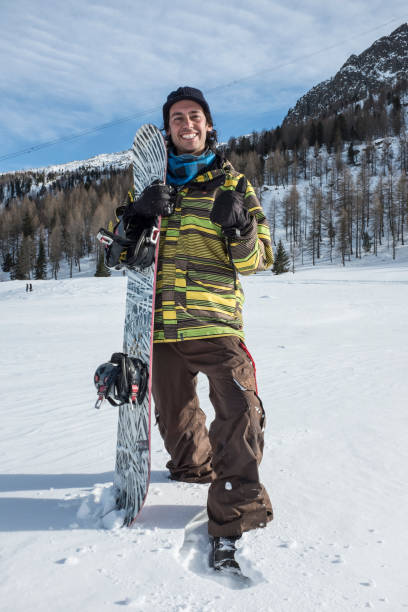 istock young man with snowboard in the mountains 1287556649