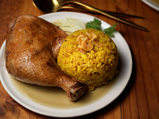 istock Chicken biryani with rice marinated in spices on wooden table in restaurant 1287556672