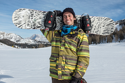 young man with snowboard in the mountains
