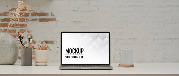 istock Workspace with laptop, supplies, paint brushes and decoration in home office 1287558287