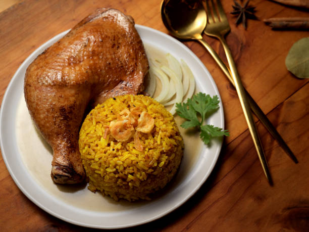 istock Chicken biryani with rice marinated in spices on wooden table in restaurant 1287558888