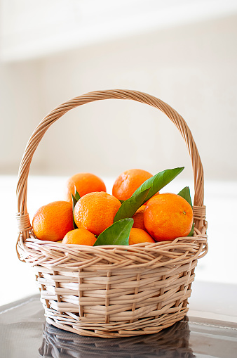 Orange clusters of juicy tangerines in basket