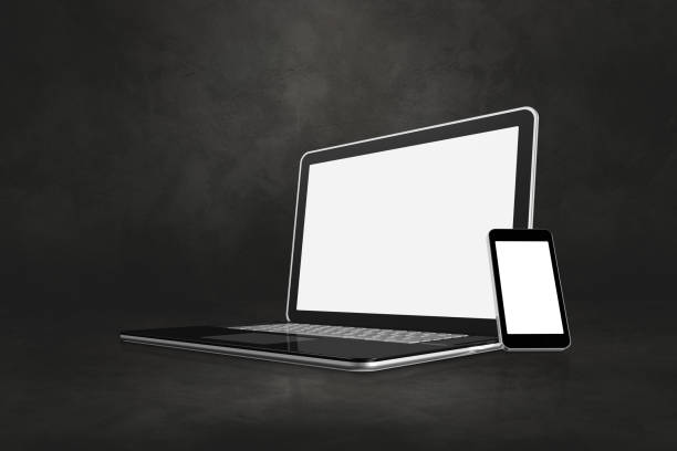 istock Laptop and mobile phone on dark concrete office scene 1287562301