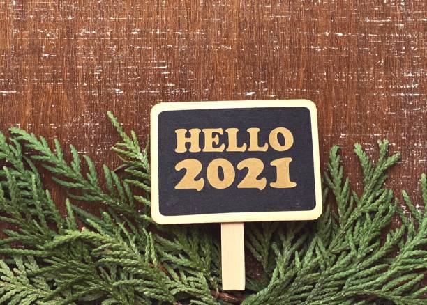 istock Hello 2021 chalkboard with fir borders on wooden background 1287563508