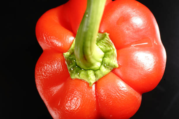 detail of three red bell peppers on white background