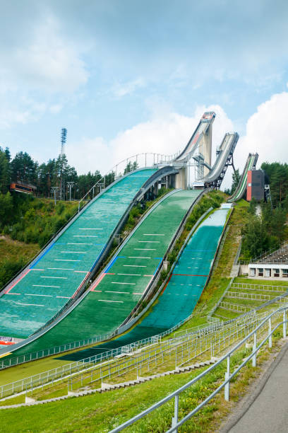 lahti sports centre with three ski jump towers. sportsman is jumping from the smallest ski jump tower. - ski jumping hill imagens e fotografias de stock