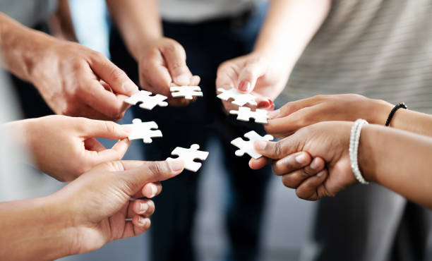 If there's a challenge, teamwork will solve it Closeup shot of a group of unrecognisable businesspeople holding puzzle pieces together jigsaw puzzle photos stock pictures, royalty-free photos & images