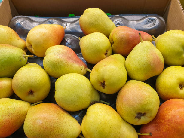 istock Ripe large yellow pears close - up on a supermarket window. 1287567006